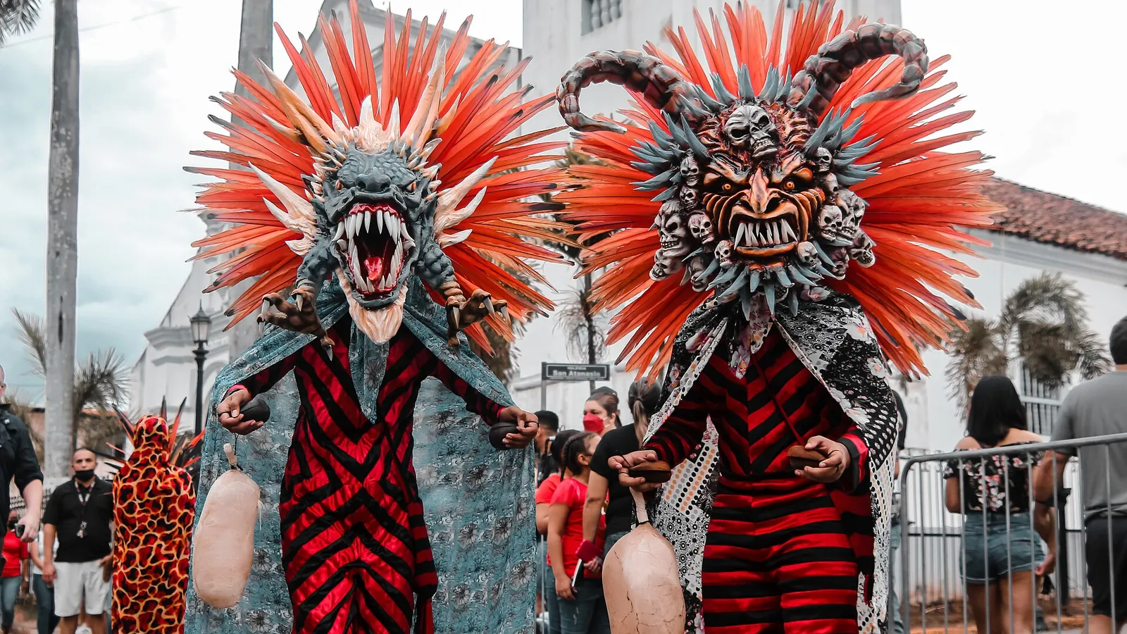 Two red and black diablico sucio dancers in front of the church at Corpus Christi, La Villa de Los Santos