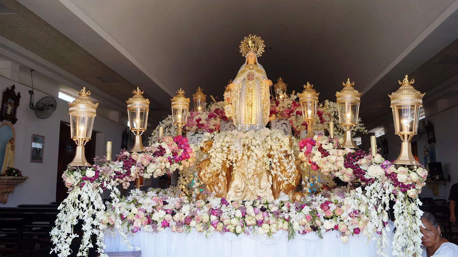 Flower-covered altar with the statue of La Merced, patron of Guararé